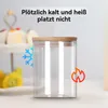 A glass storage jar with a wooden lid, shown with icons representing cold and heat, and text indicating resistance to temperature changes. Produktbild-Vorschau