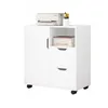 A white rolling cabinet with a printer and some books on top and in the open shelf. The cabinet has one door and two drawers. Podgląd zdjęcia produktu
