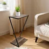 A small side table with a plant on it, next to a sofa. Anteprima dell’immagine prodotto