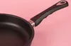 A close-up shot of a black frying pan with a black handle against a pink background. Náhľad obrázku produktu