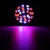 A close-up of a grow light bulb with multiple LEDs emitting red, blue, and white light, casting a purple glow on a dark surface. Anteprima dell’immagine prodotto