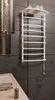A white electric towel warmer mounted on a dark tiled wall in a bathroom. Náhľad obrázku produktu