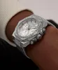 A close-up shot of a silver Guess watch with sparkling details on a person's wrist. Produktbild-Vorschau