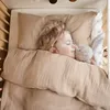 A young child sleeping in a crib with a stuffed bunny. Produktbild-Vorschau