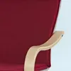 A close-up of a red upholstered chair with a light wood armrest. Produktbild-Vorschau