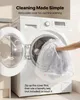 A person's hand is placing a laundry bag into a washing machine. Anteprima dell’immagine prodotto