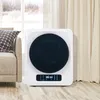 A white mini-washing machine with a black circular front is placed on a wooden floor next to a sofa. Curtains and a window with a winter scene are in the background. Produktbild-Vorschau