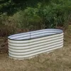 A raised garden bed is placed on dry grass in an outdoor setting with trees and foliage in the background. Produktbild-Vorschau