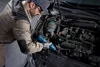 A mechanic is working on a car engine. Produktbild-Vorschau