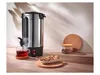 A hot beverage dispenser is shown on a wooden table, with a cup of tea, cookies, and a jar of coffee beans. Produktbild-Vorschau
