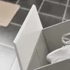 A close-up view of a white panel and a gray fabric storage bin with a white cloth inside. Produktbild-Vorschau