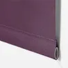 A close-up view of the bottom edge of a purple roller blind, showing the fabric rolled around a tube. Produktbild-Vorschau