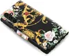 A close-up, angled view of a black flip phone case with a detailed floral and ornate gold pattern. Produktbild-Vorschau
