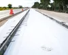 Construction site with white fabric laid out for road or drainage work, with rebar visible. Produktbild-Vorschau