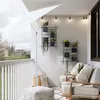 A balcony furnished with seating, plants, and an umbrella. Produktbild-Vorschau