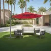 An outdoor patio scene with a red cantilever umbrella shading a seating set on artificial grass. Produktbild-Vorschau