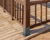 A close-up view of a wooden deck railing post with a metal base anchor. Náhled obrázku produktu