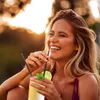 A woman is enjoying a drink outdoors during sunset. Voir les images du produit