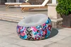 An inflatable chair with a graffiti-style pattern sits on a paved patio next to some lounge chairs and a potted plant. Produktbild-Vorschau