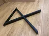 Two black metal table legs are arranged in an X shape on a wooden floor. Anteprima dell’immagine prodotto