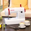 A sewing machine is displayed on a table with two cups of coffee and sewing supplies. Produktbild-Vorschau