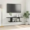 A black TV stand mounted on a white wall, with a TV mounted above it. Decorative items and books are on the stand. A floor lamp is to the left, and a potted plant is to the right. Náhľad obrázku produktu