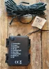 A bundle of LED string lights and their battery-powered control box are laid out on a wooden surface. Produktbild-Vorschau