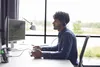 A man wearing a headset is working at a computer in an office setting. Náhled obrázku produktu