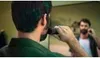 A man is trimming his beard in front of a mirror. Produktbild-Vorschau