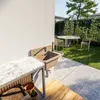 An outdoor sink and countertop area in a garden setting with a table and chairs in the background. Produktbild-Vorschau