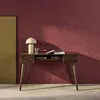 A wooden desk with drawers, a lamp, and some decorative items against a textured maroon wall. Anteprima dell’immagine prodotto