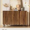 A modern wooden sideboard with decorative doors is displayed in a well-lit room, showcasing its design and some decorative items on top. Voir les images du produit