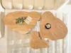 A set of three irregularly shaped wooden coffee tables on a rug in front of a sofa. Anteprima dell’immagine prodotto