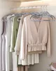 A row of clothes hanging on gray hangers in a closet. Produktbild-Vorschau