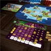 A board game setup on a wooden table, showing game boards, pieces, and cards. Produktbild-Vorschau