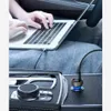 A person using a laptop in a car, with a car charger plugged into the car's power outlet. Náhľad obrázku produktu