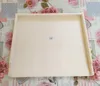 A wooden board with a raised edge, lying on a floral patterned tablecloth. Anteprima dell’immagine prodotto