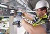 A construction worker is using a Bosch cordless drill to install a metal cable tray system. Produktbild-Vorschau