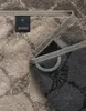 A close-up view of two folded towels, one in beige and one in dark gray, with a visible brand tag. Produktbild-Vorschau