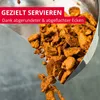 A scoop of döner/gyros meat is being poured out of a metal scoop. Produktbild-Vorschau