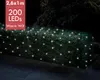 A hedge decorated with a net of warm white LED lights at night. Produktbild-Vorschau