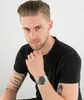 A man wearing a black t-shirt and a watch on his left wrist, posing against a white background. Náhľad obrázku produktu