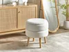 A white bouclé stool with wooden legs is placed in a room with a wooden cabinet and a tall mirror. Náhled obrázku produktu