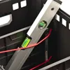 A close-up view inside a black tool crate, showing a silver level tool with green liquid bubbles, and red wires. Voir les images du produit