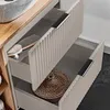 Close-up view of open drawers of a bathroom vanity, showing storage items. Produktbild-Vorschau