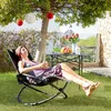 A woman relaxes in a folding lounge chair in a garden, under a tree decorated with hanging lanterns. Anteprima dell’immagine prodotto