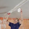 A man is applying joint compound to a ceiling seam with a trowel and tape. Produktbild-Vorschau