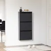 A gray shoe cabinet with three flip-down doors is mounted on a white wall. Náhled obrázku produktu