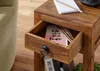 A close-up of a wooden side table with an open drawer. Náhled obrázku produktu