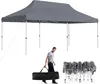 A man is carrying a folded tent in a bag next to a set-up tent. Anteprima dell’immagine prodotto